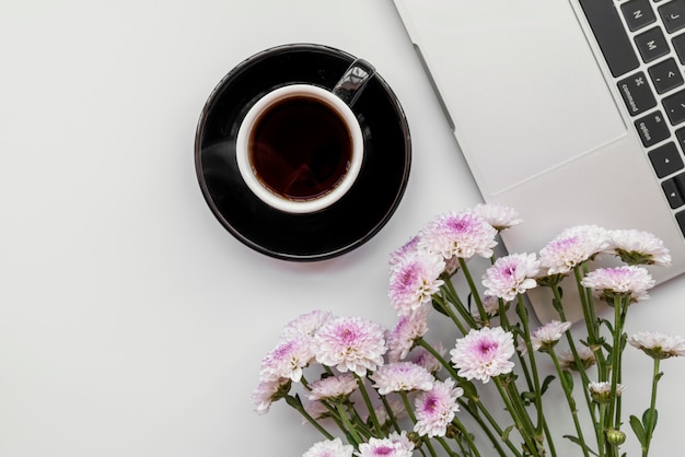 Free Photo flat lay with flowers and laptop with cup of coffee