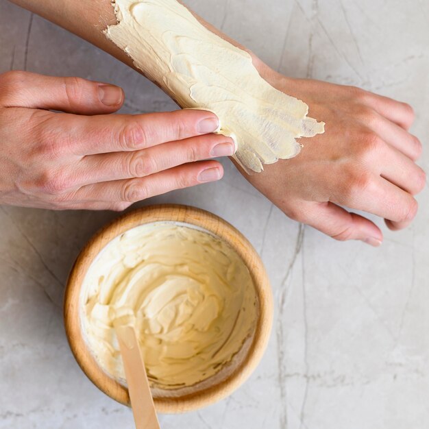 Flat lay of woman applying lotion on her hands