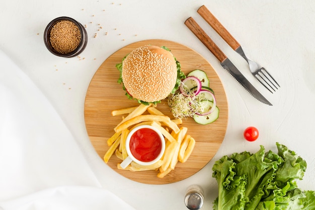 Flat lay wooden board with hamburger and fries