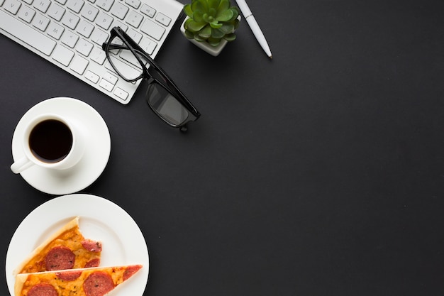 Free Photo flat lay of work desk with keyboard and pizza