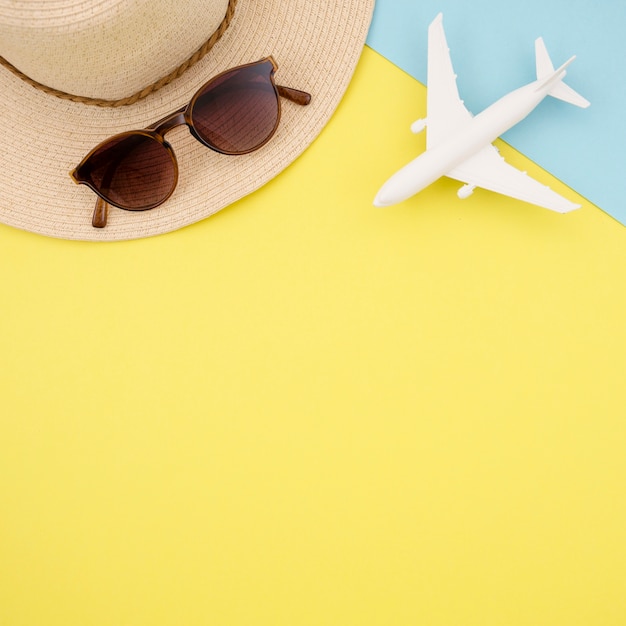 Flat lay of yellow background with hat and glasses