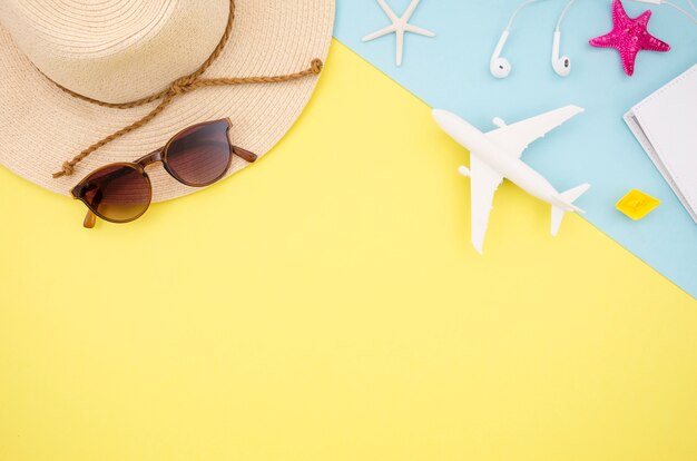 Flat lay of yellow background with hat and toy plane