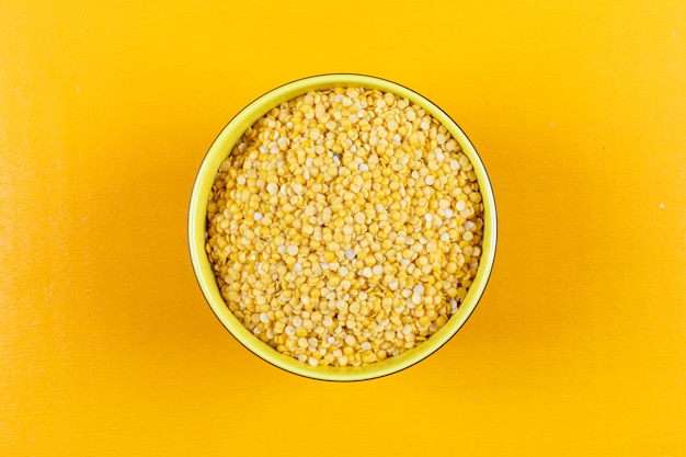 Flat lay yellow lentils in yellow bowl