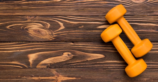 Flat lay of yellow weights on wooden background and copy space