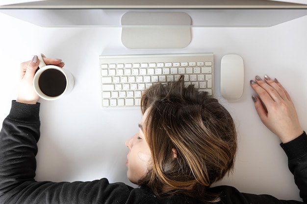 Free Photo flat lay young woman asleep in front of a computer