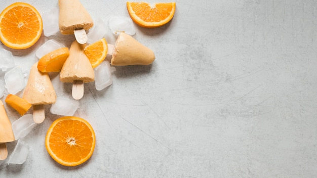 Free photo flat lay of yummy orange flavored popsicles with copy space