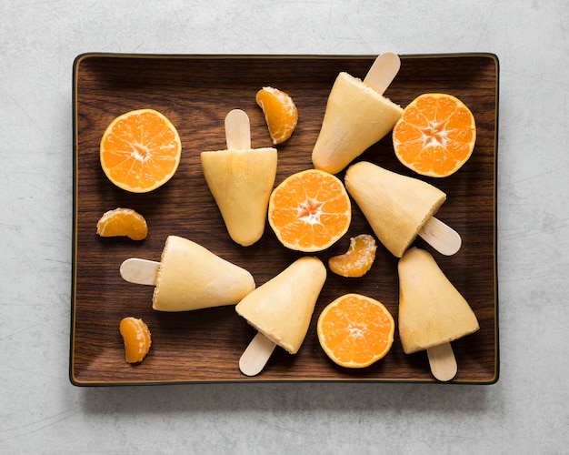 Free photo flat lay of yummy orange flavored popsicles