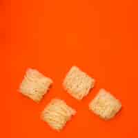 Free photo flat raw noodles over vibrant orange background