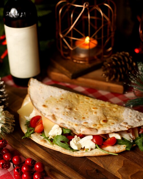 Flatbread wrap filled with cherry tomato arugula and mozzarella