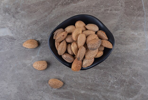 Flavorful almonds in the bowl on the marble surface