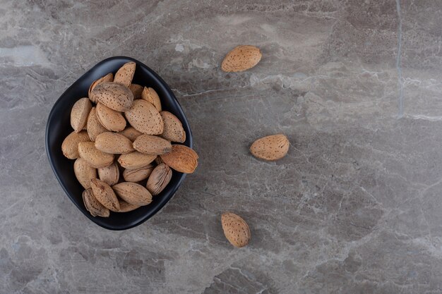 Flavorful almonds in the bowl on the marble surface