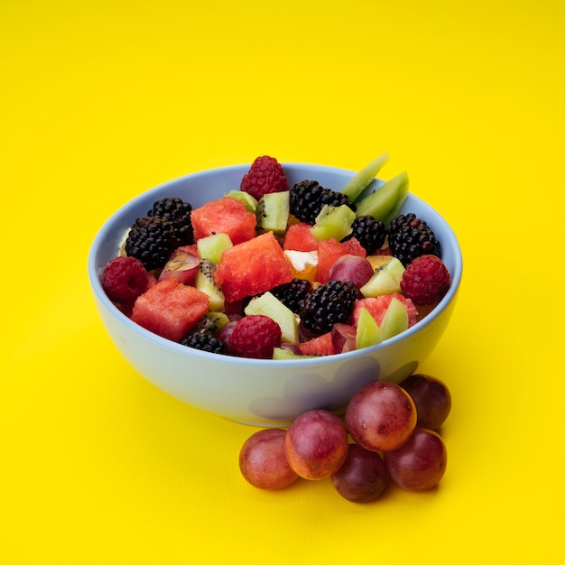 Flavorful fruit salad on yellow background