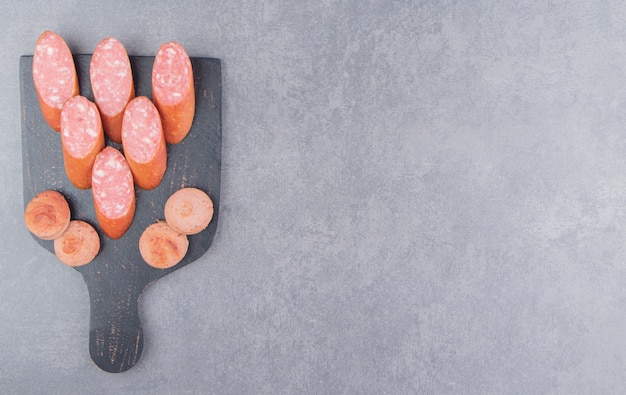 Free Photo flavorful sliced sausage, on the board, on the marble surface