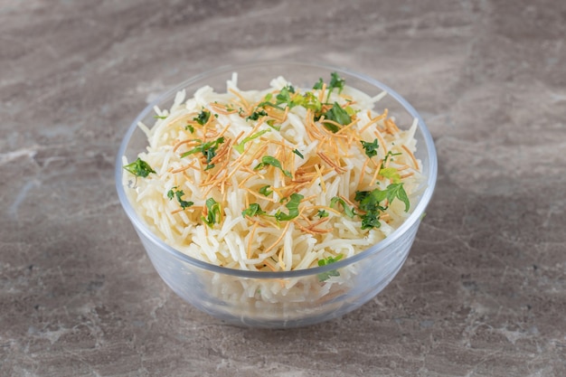 Flavorful vermicelli pasta with green vegetable in the bowl , on the marble.