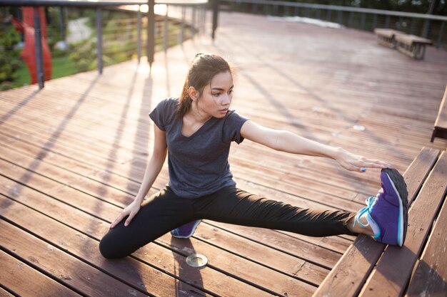 Flexible young woman stretching her left leg