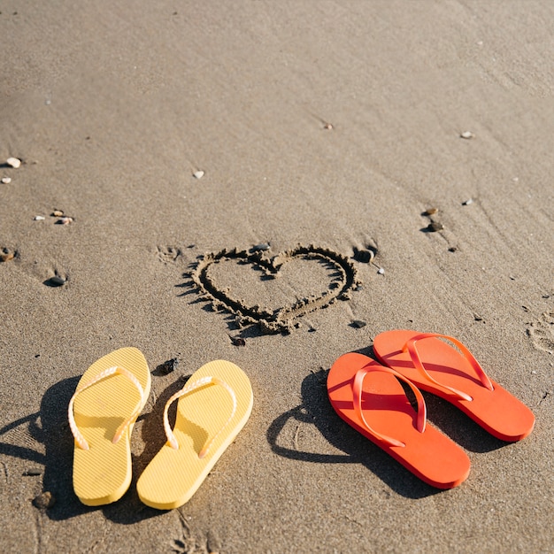 Free photo flip flops in the sand at the beach