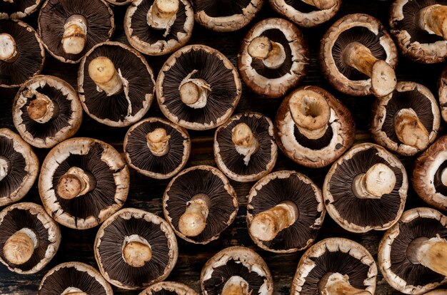 Flipped mushrooms on a dark wooden table. top view.