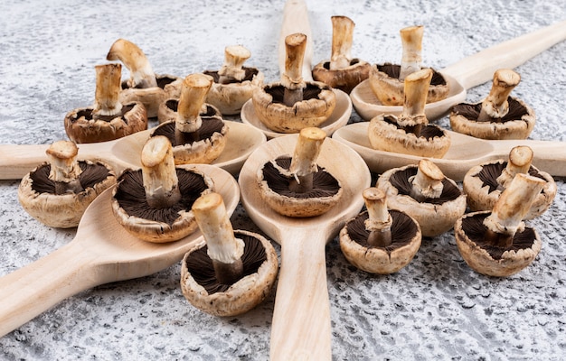 Free photo flipped mushrooms in spoons on a gray table