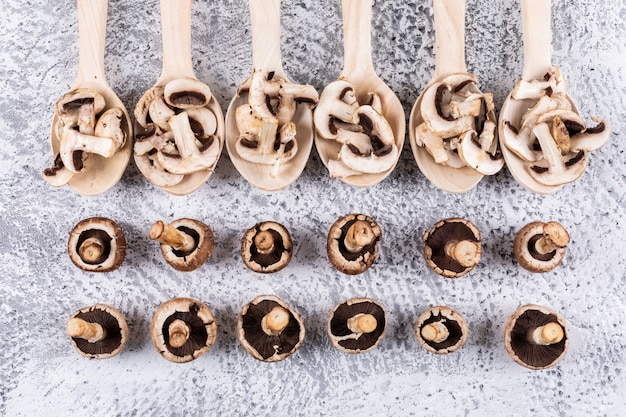 Free Photo flipped, sliced mushrooms in spoons on a gray table