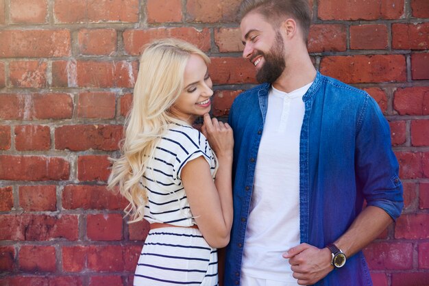 Flirting next to a brick wall