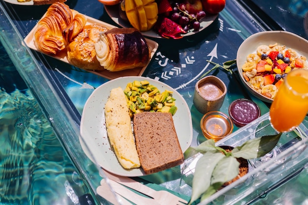 Free photo floating breakfast at amazing hotel villa in blue swimming pool