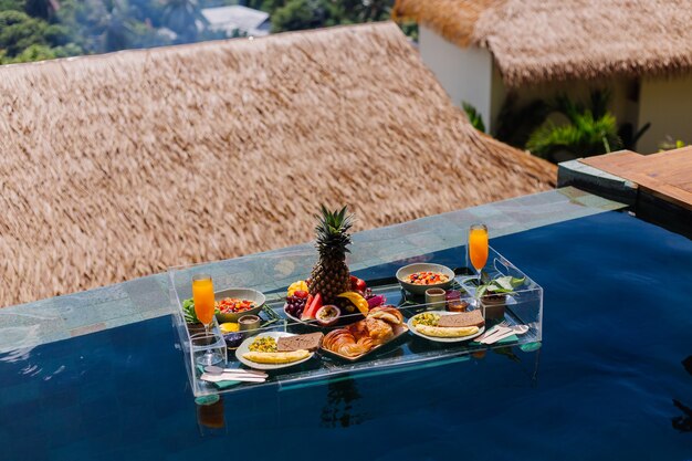 Floating breakfast at amazing hotel villa in blue swimming pool