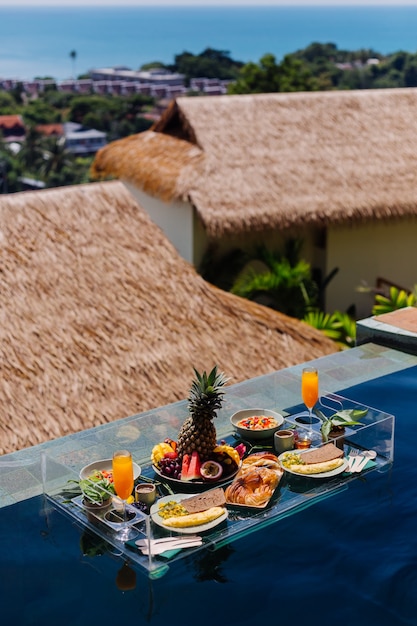 Floating breakfast at amazing hotel villa in blue swimming pool