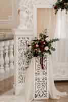 Free photo floral composition on the white arch in the wedding ceremonial hall