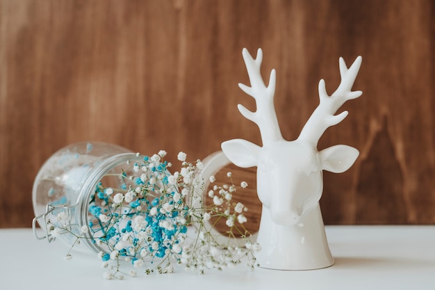 Free Photo floral composition with glass and deer