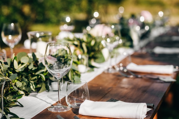 Floral garland of eucalyptus lies on the wedding dinner table