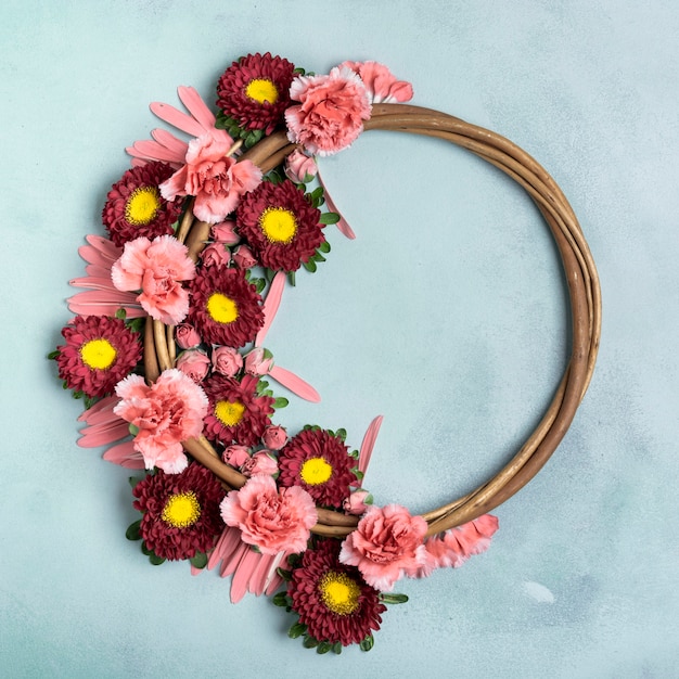 Free photo floral wreath with carnations and daisies with copy space