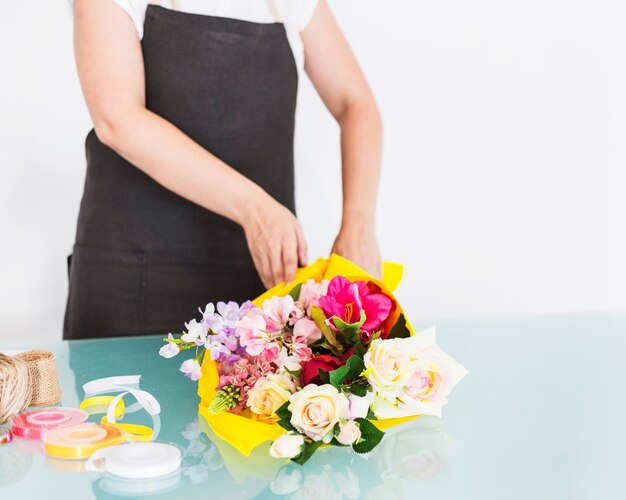 Florist arranging bunch of flowers on desk