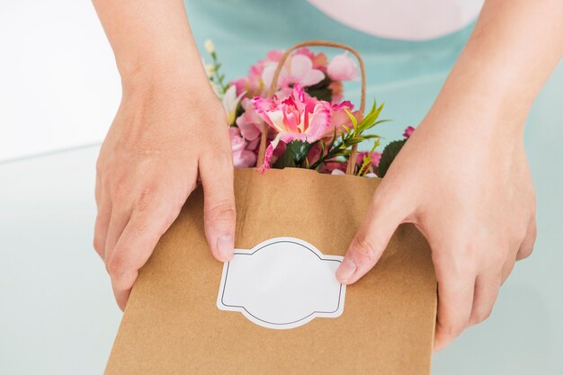 Florist hand holding paper bag full of flowers