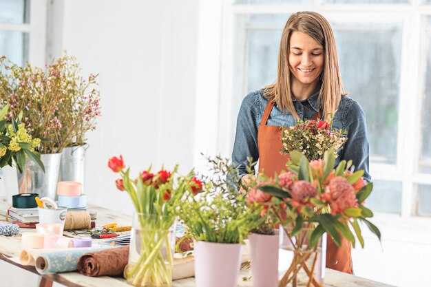 florist making bouquet of different flowers