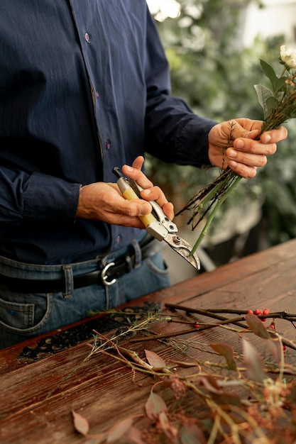 Florist male cutting the flower stalks