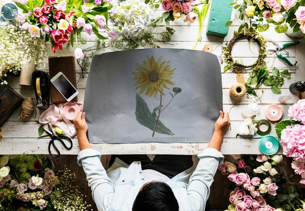 Florist Showing Empty Design Space Paper on Wooden Table with Fresh Flowers Decorate