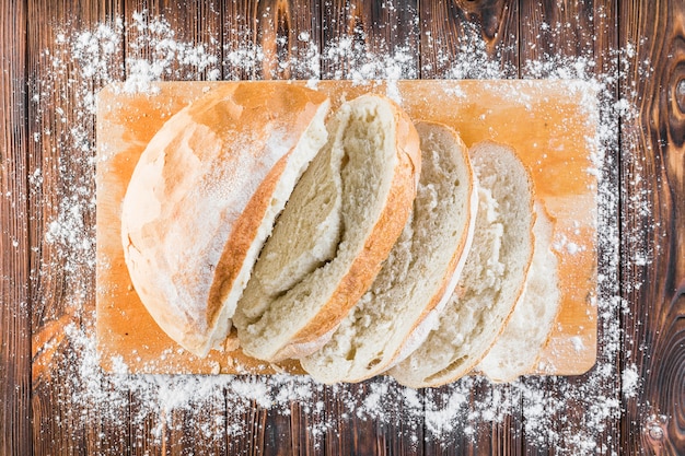 Free Photo flour border over the edge of chopping board with bread slices