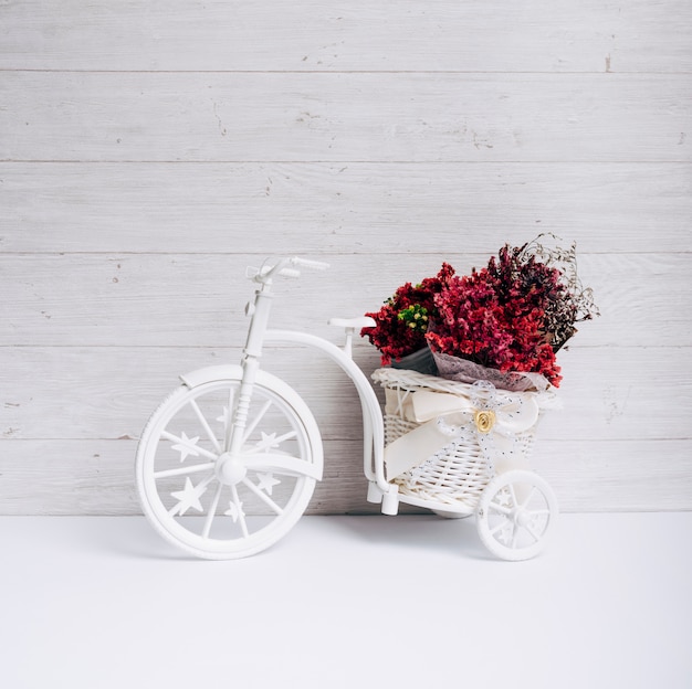 Free Photo flower basket in the white bicycle on desk against wooden wall