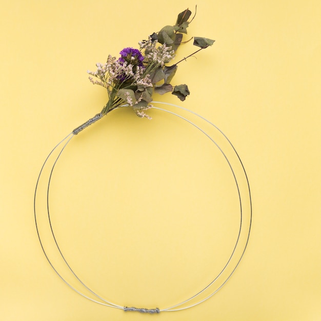 Free photo flower bouquet on empty metallic ring over the yellow backdrop