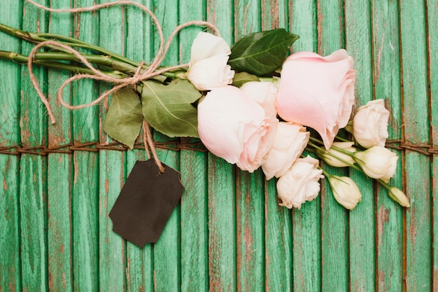 Free photo flower bouquet and tag tied with string on wooden shutter backdrop