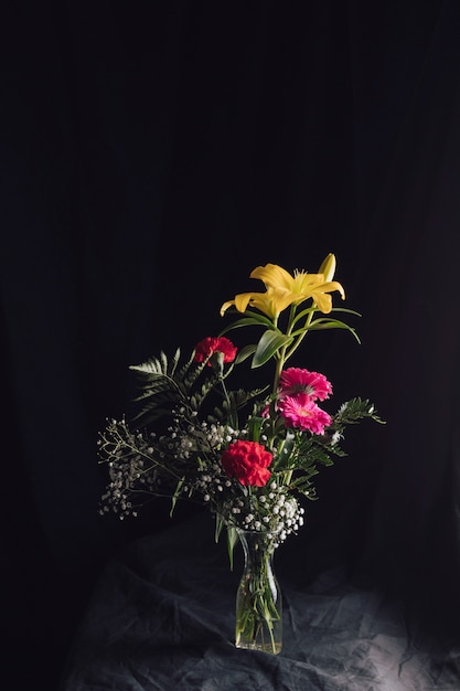 Free photo flower bouquet in vase on dark textile