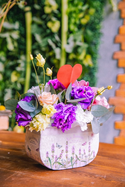 Flower composition in paper box creamy roses lilac and white lithianthus