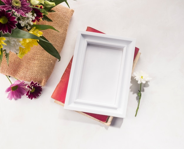 Free photo flower composition and photo frame on grey desk