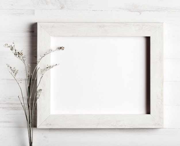 Free photo flower and a frame on wooden wall