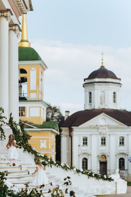 Flower girls walk upstairs before old Russian church