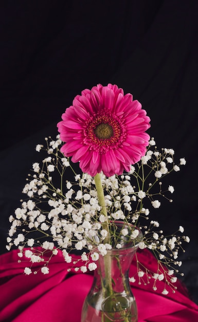 Free Photo flower with bloom twigs in vase near rose textile in darkness