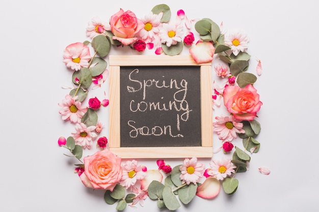 Free Photo flowers around chalkboard with writing