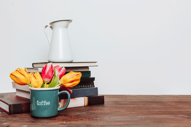 Flowers near books and jug