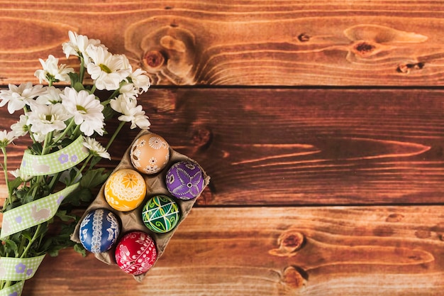 Free photo flowers near carton with eggs