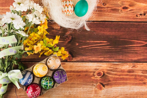 Free photo flowers near nest and egg carton